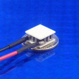 image of mini micro peltier TEC cooler module 00711-5L31-04CB shown sitting on USA Dime 10 cent coin for scale