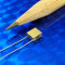 image of micro thermoelectric TEC module 00701-9B30-22RU4 shown next to pencil tip for scale